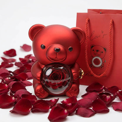 Luxury red teddy bear holding rose in glass dome with romantic gift bag and rose petals